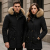 Homme et femme portant des parkas longues noires avec capuches en fourrure, style élégant pour l'hiver.