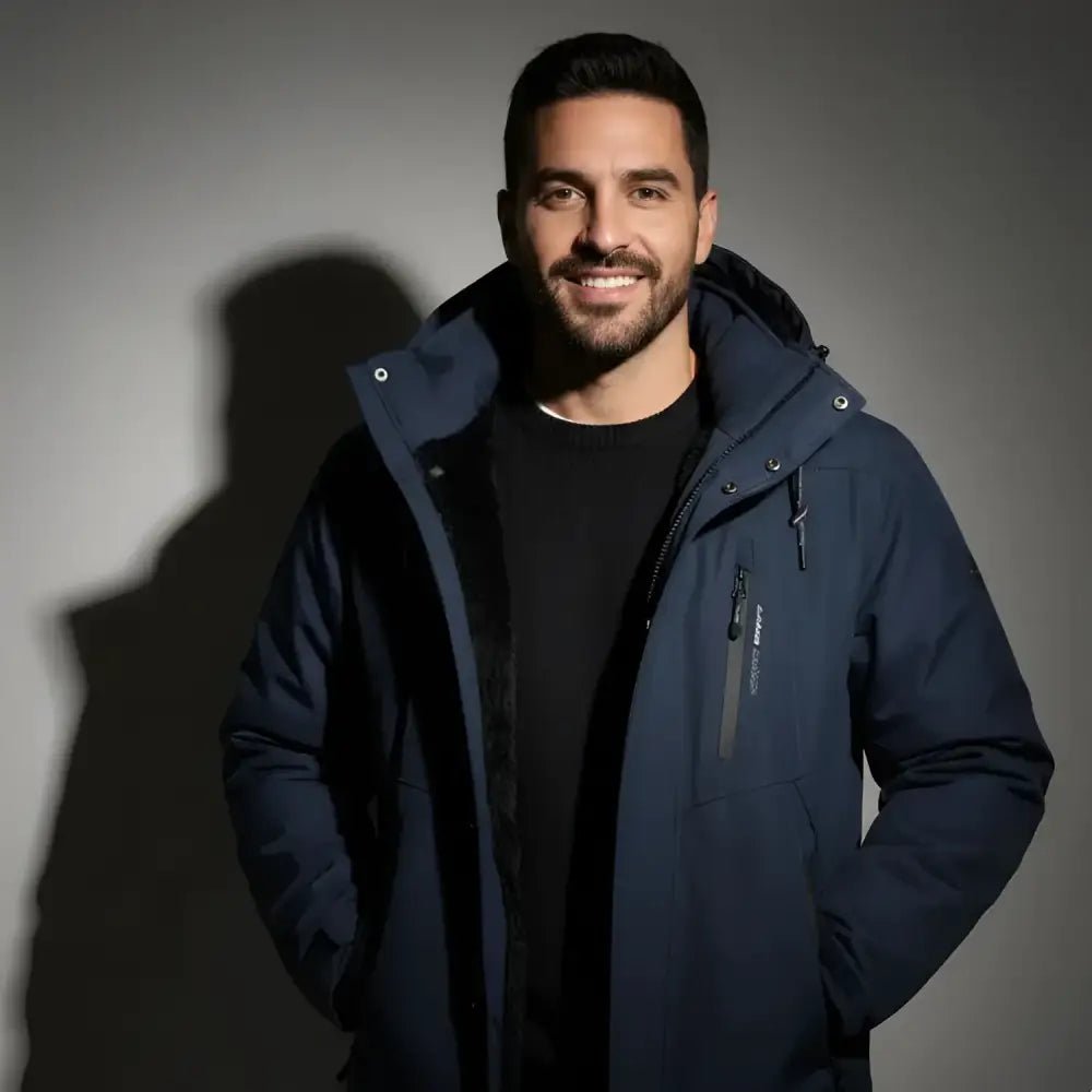 Homme souriant portant une parka homme bicolore à capuche, mettant en avant le style et la protection.