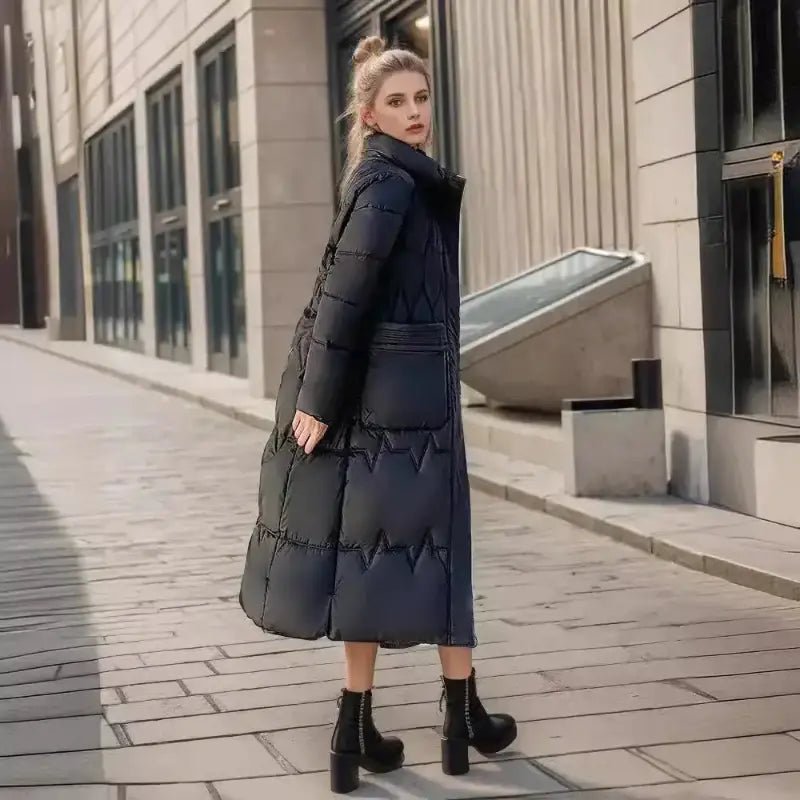 Parka femme matelassée hiver noire longue portée par une femme dans une rue moderne.