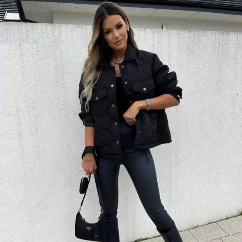 Parka femme courte matelassée noire portée par une femme avec un sac. Idéale pour l'hiver.