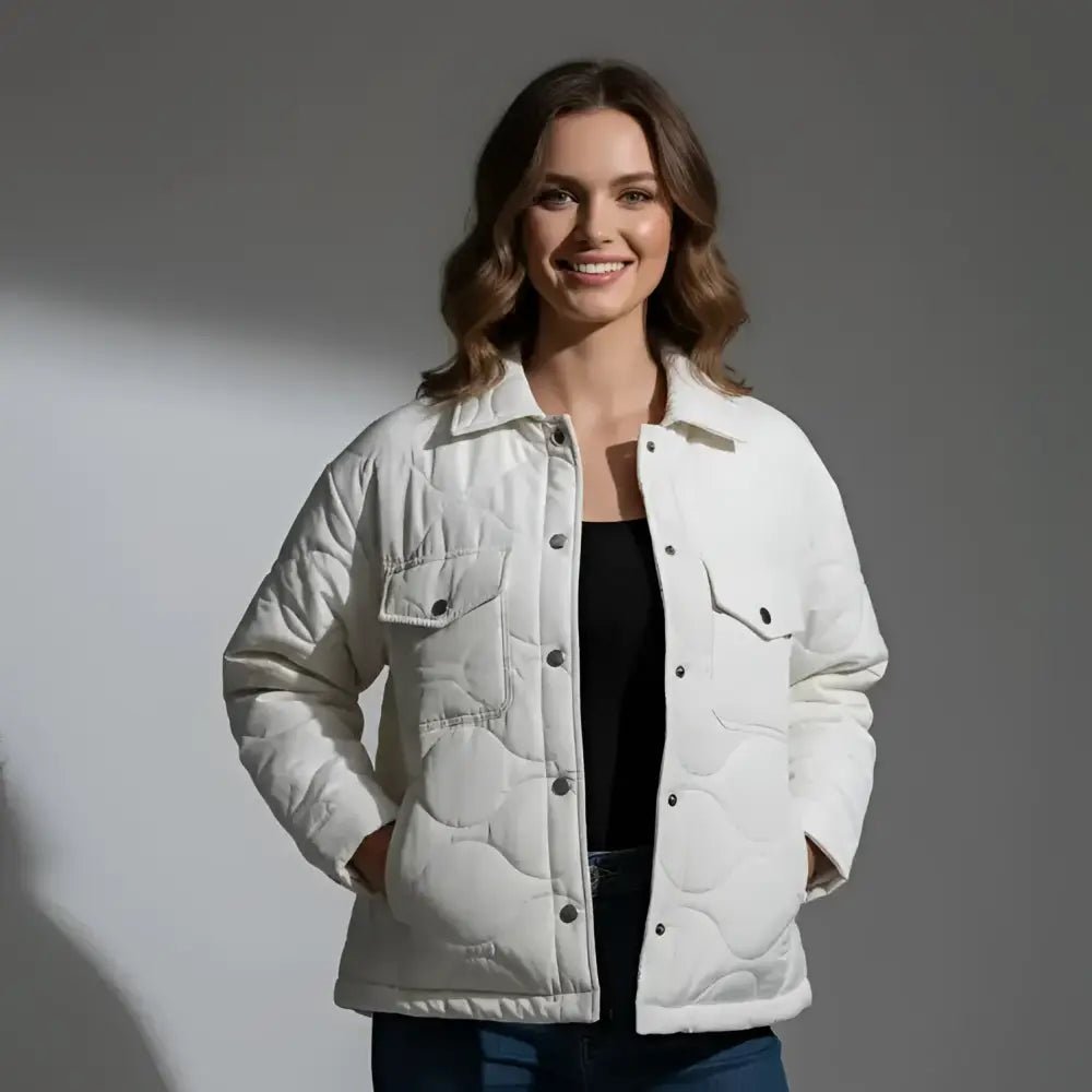 Parka femme courte matelassée blanche portée par un modèle devant un fond neutre.