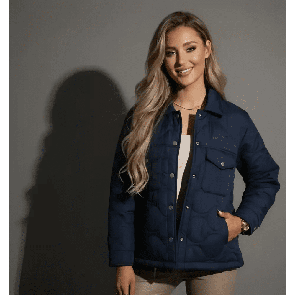 Parka femme courte matelassée bleue portée par un modèle souriant sur fond neutre.