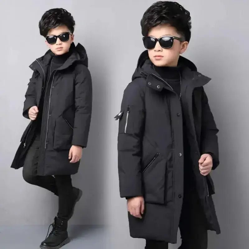 Parka enfant garçon à capuche noire portée par un jeune garçon élégant avec lunettes de soleil.