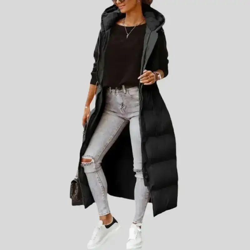 Parka femme sans manches vert militaire matelassée portée avec un jeans gris et des sneakers blanches.