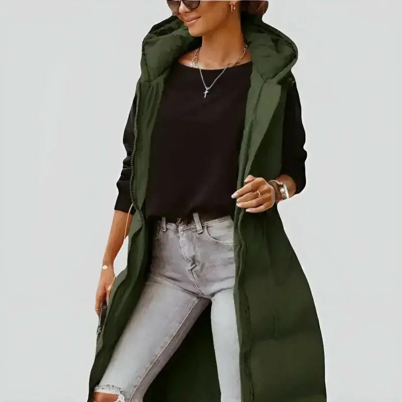 Parka femme sans manches vert militaire matelassée portée avec un haut noir et un jean.