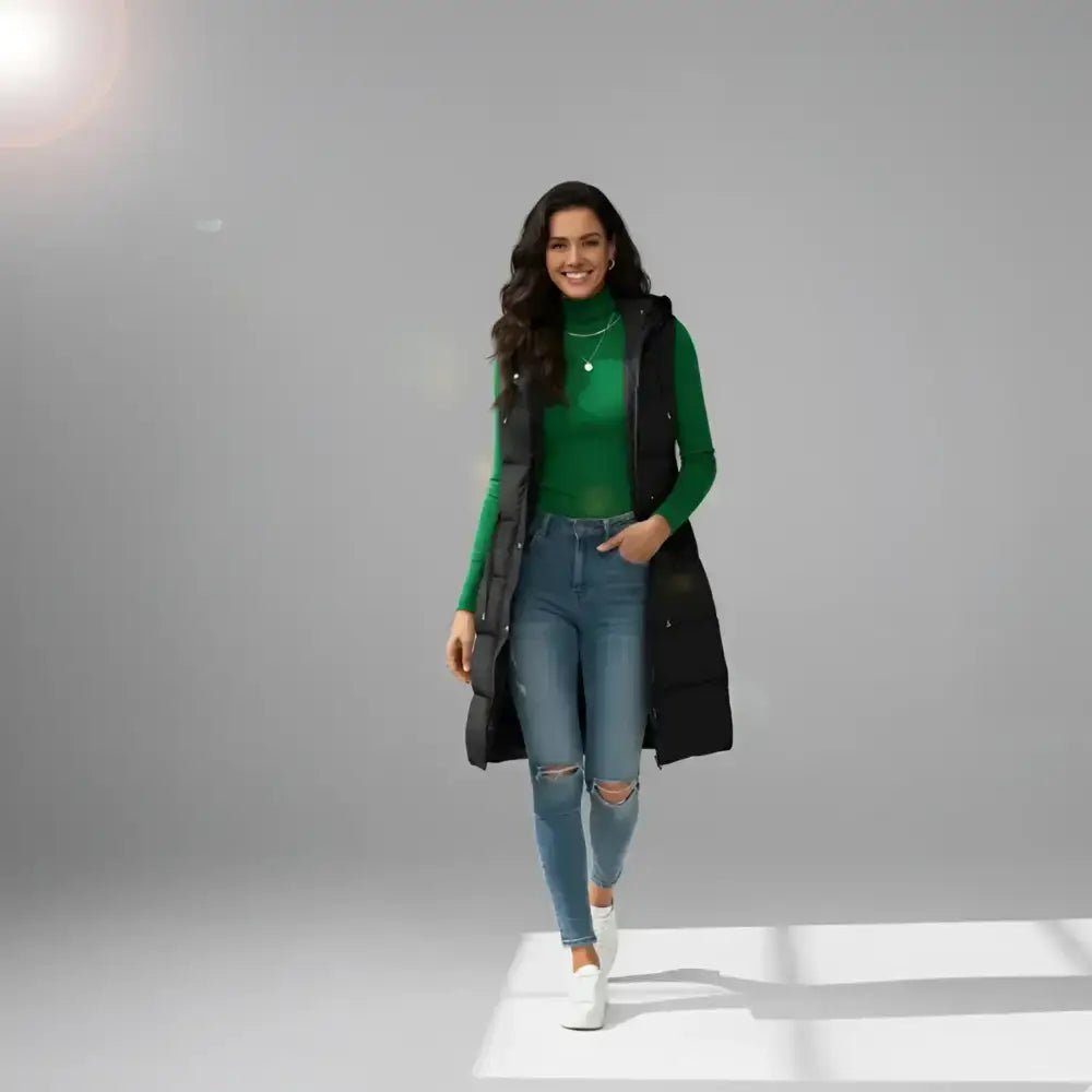 Parka femme sans manches vert militaire matelassée portée avec un pull vert en banlieue.