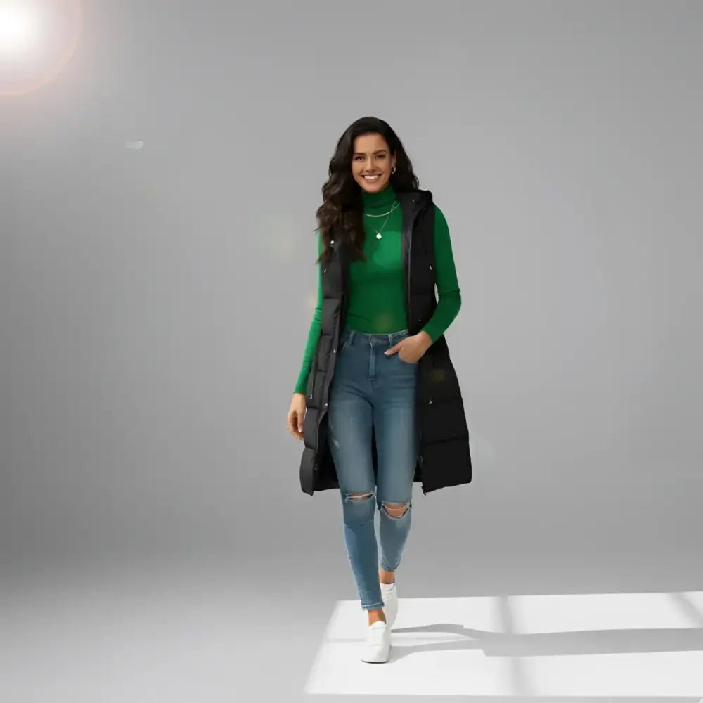 Femme chaude imperméable avec long noir puffer vest, turtleneck vert et jeans déchirés