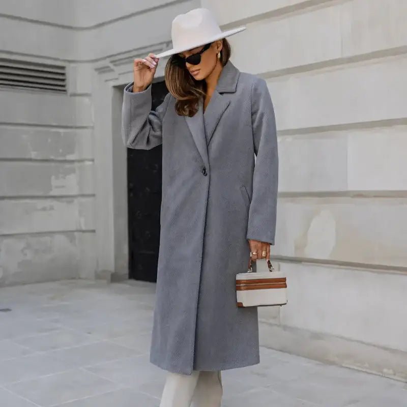 Parka femme hiver col tailleur gris portée sur une tenue élégante avec un chapeau.