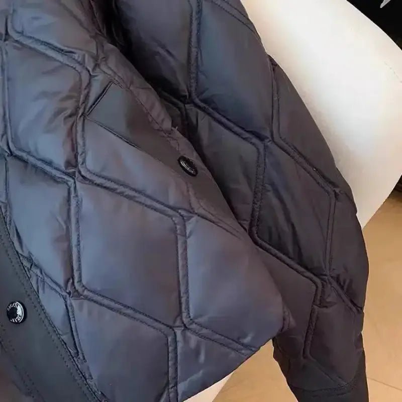 Détail de la parka femme courte bombardier en polyester matelassé, couleur noire, sur fond clair.