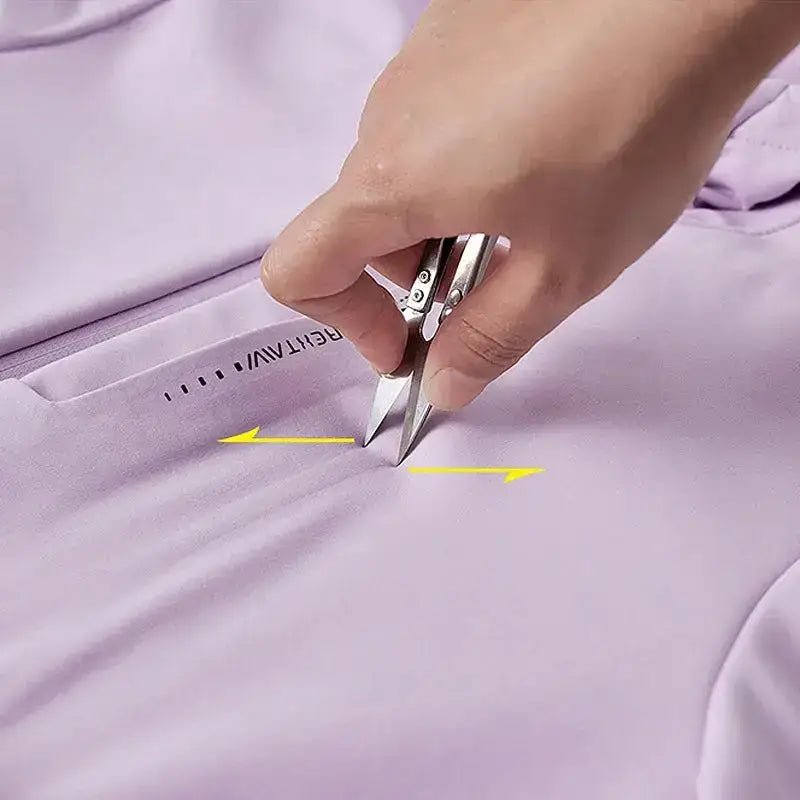 Femme coupant un tissu violet avec des ciseaux pour ajuster une parka femme à capuche cintrée.