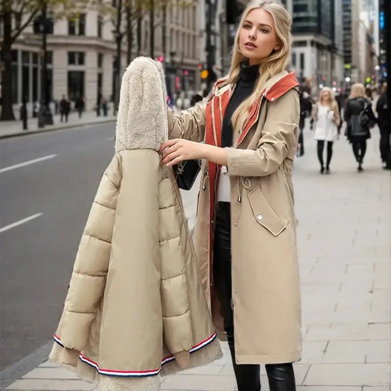 Parka femmes hiver : femme élégante tenant une parka beige avec col en fausse fourrure en ville.
