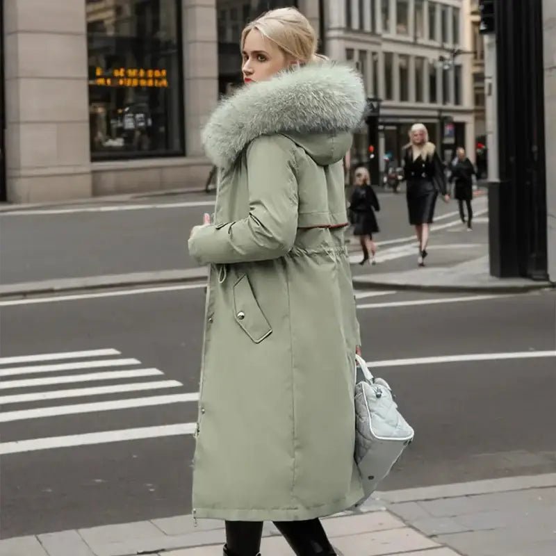 Parka femme hiver col fausse fourrure kaki portée dans une rue urbaine en hiver.