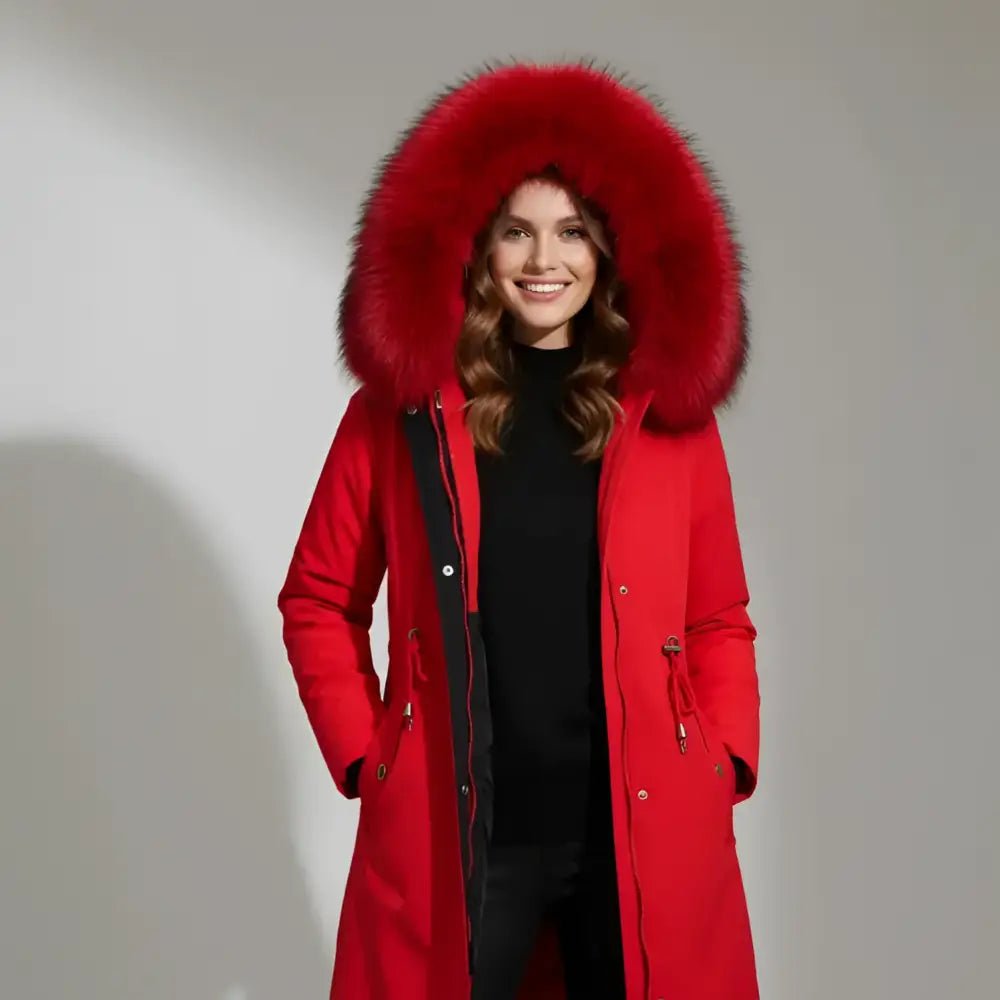 Parka femme hiver col fausse fourrure rouge avec capuche sur une modèle souriante.