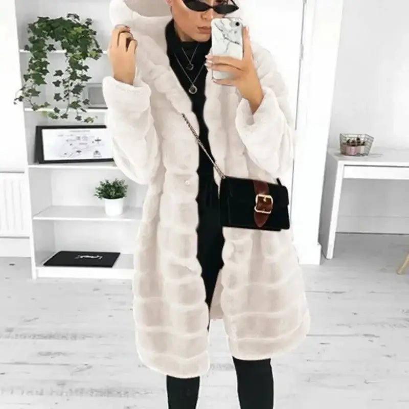 Parka femme longue capuche fourrée d'une couleur blanche, portée avec un sac et des lunettes de soleil.