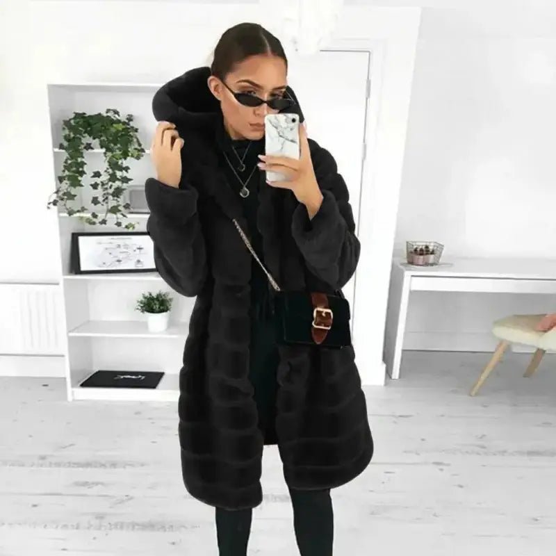 Parka femme longue capuche fourrée noire portée avec style, idéale pour les journées froides.