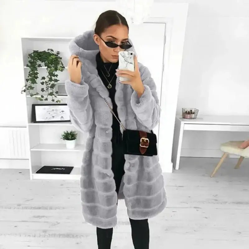 Femme portant une parka femme longue capuche fourrée gris, stylée avec des lunettes de soleil.