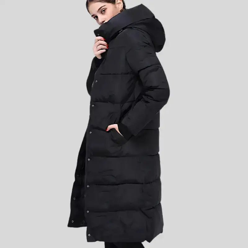 Parka grande taille femme matelassée noire longue portée par un modèle sur fond gris.