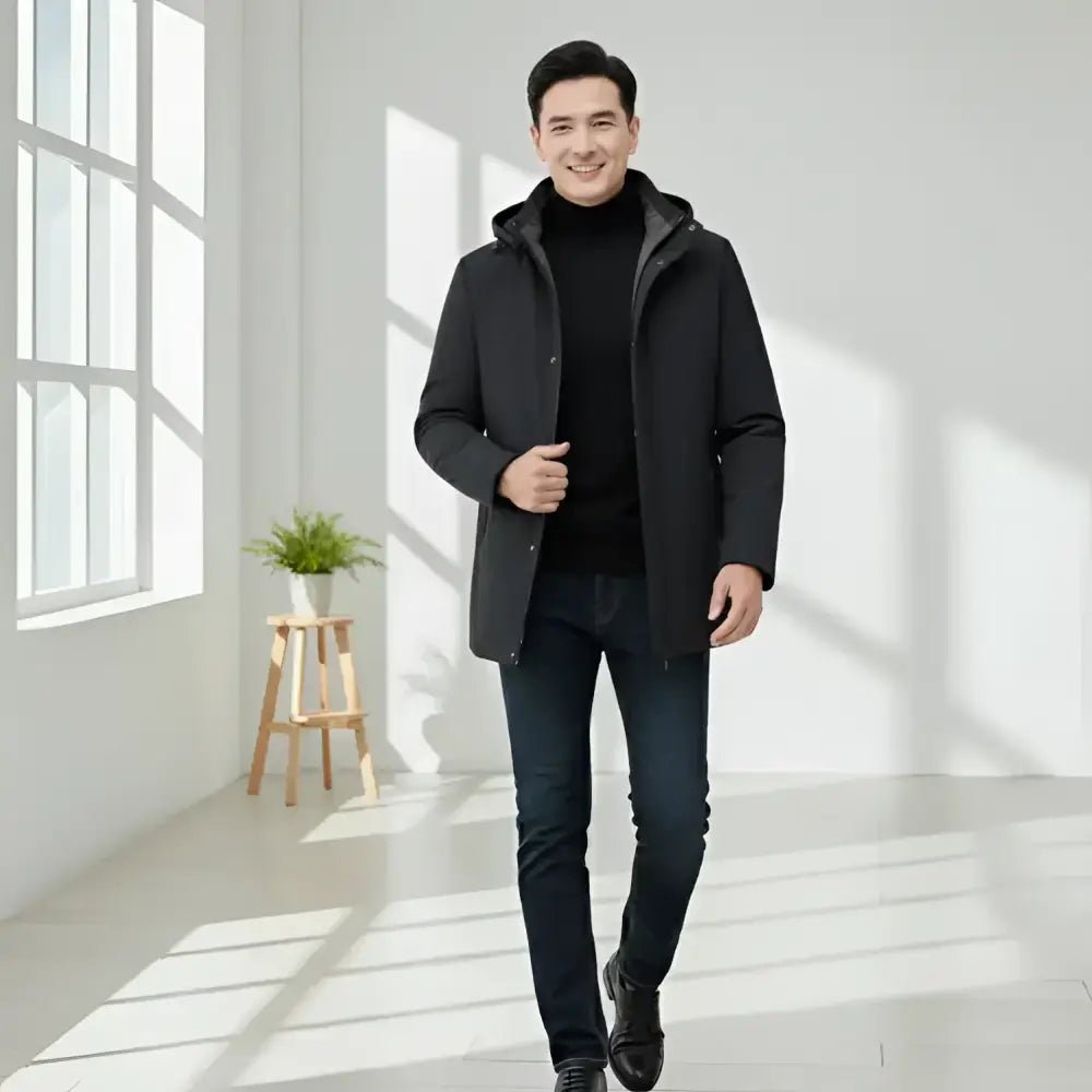 Parka homme bleu marine à capuche porté par un homme souriant dans un intérieur lumineux.