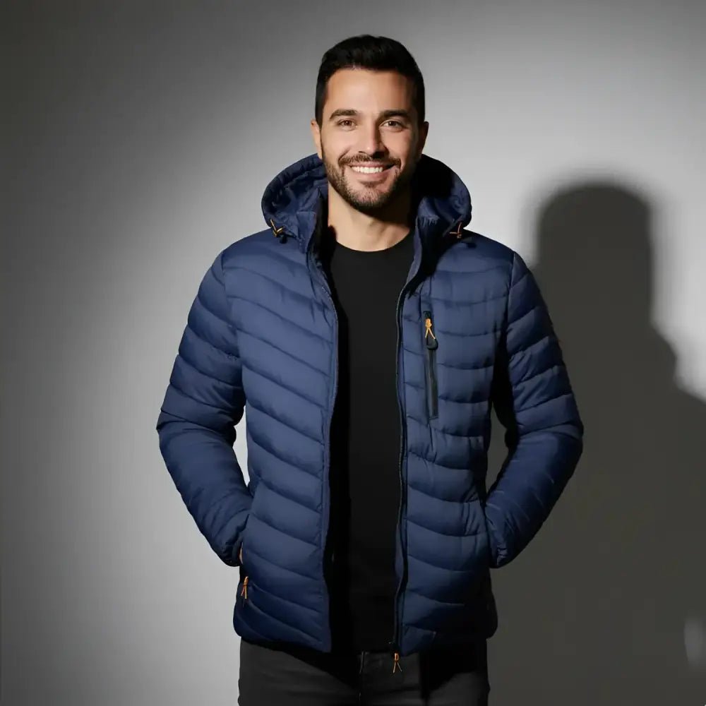 Parka homme matelassée multicolore présentée par un modèle souriant, couleur bleu marine, à capuche et matelassée.