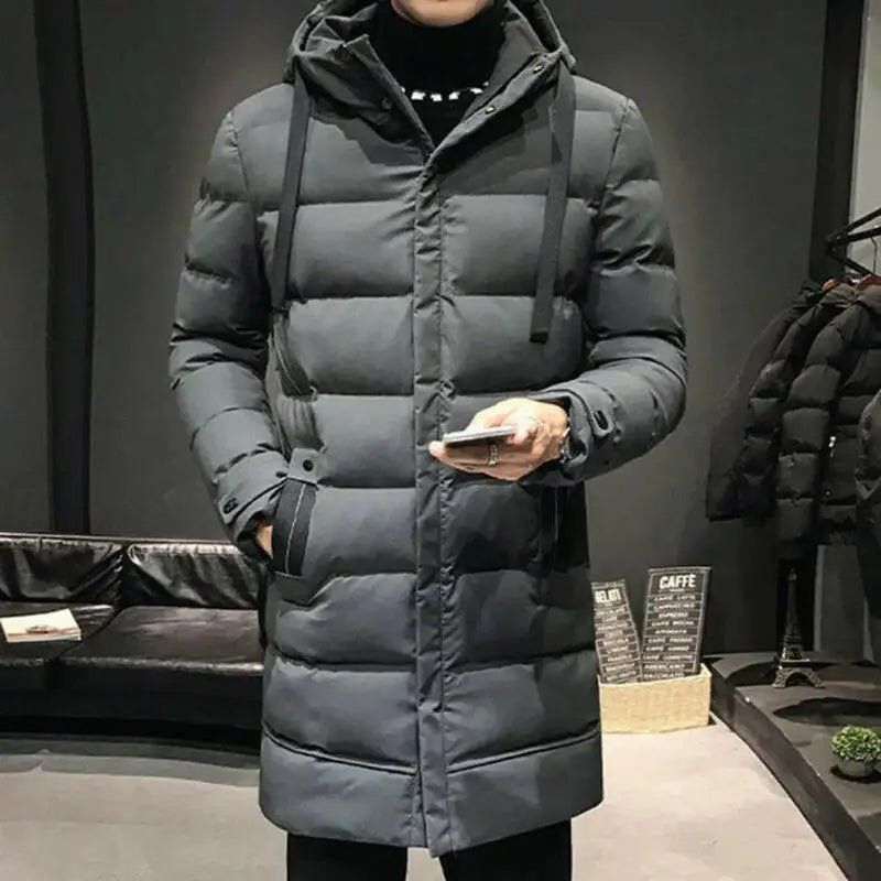 Parka homme grise longue matelassée portée, idéale pour les grands froids urbains, style et confort.