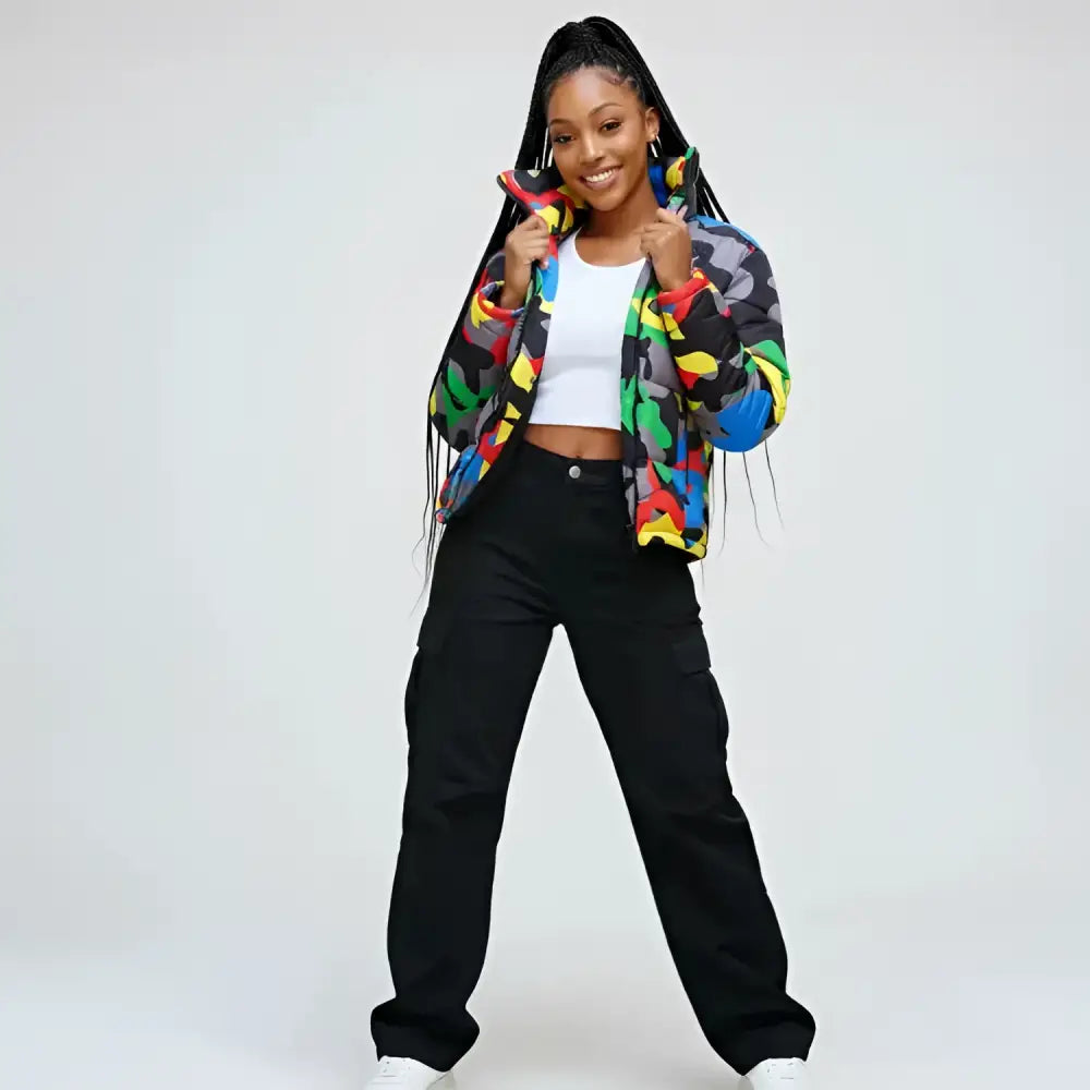 Femme portant un parka imperméable coloré, crop top blanc et pantalons cargo noirs