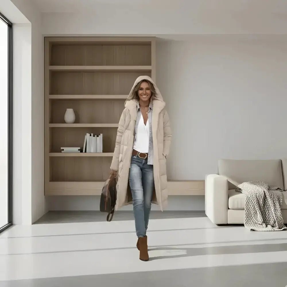 Femme portant une parka femme fourrée à capuche dans un intérieur moderne.