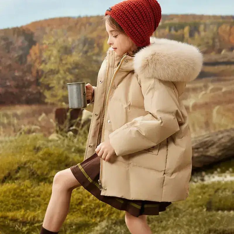 Parka imperméable fille noire avec capuche portée par une fille, vêtue d'un bonnet rouge en plein air.