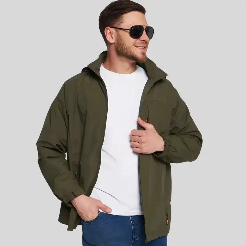 Homme portant une parka homme imperméable légère de couleur vert militaire, avec lunettes de soleil, sourire.