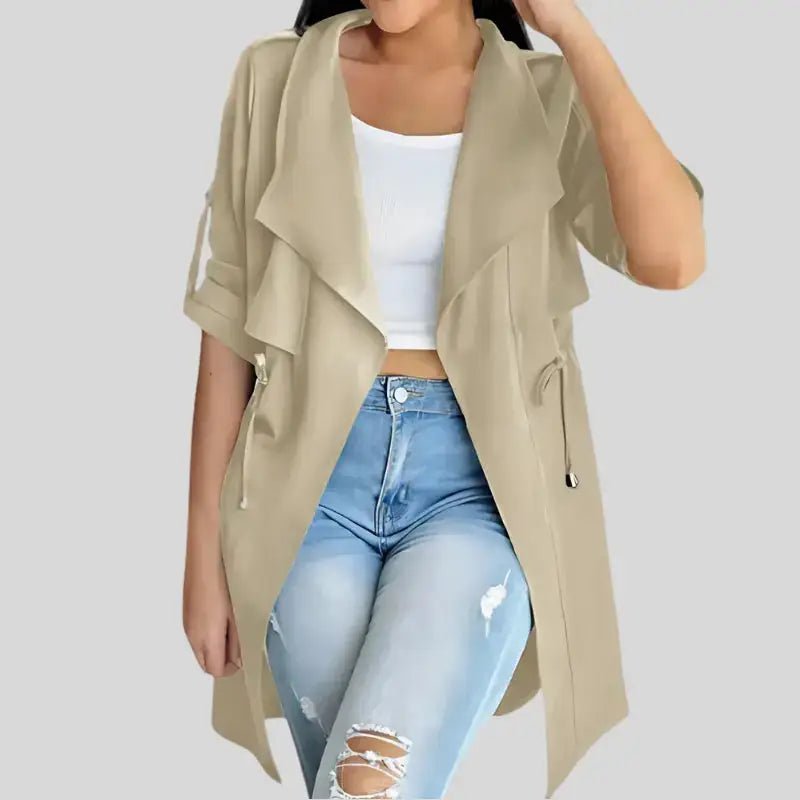 Parka kaki femme légère ceinturée portée par une femme, associée à un haut blanc et un jean déchiré.