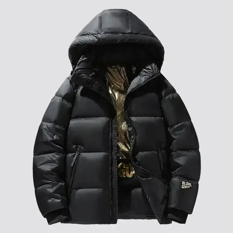 Parka longue femme imperméable avec capuche noire en tissu déperlant et garnissage matelassé.