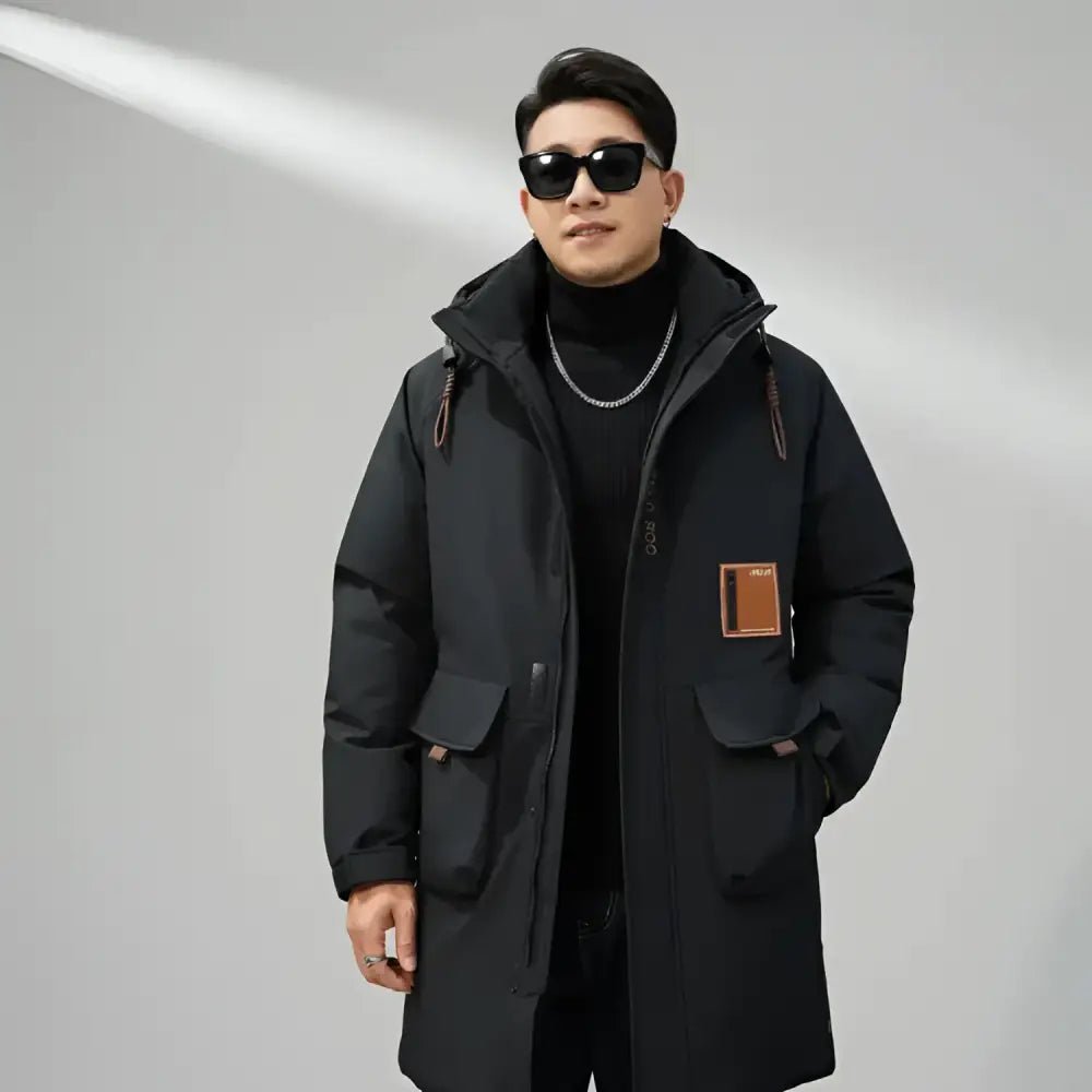Parka longue homme grande taille noire – Le Titan portée par un homme au style moderne avec lunettes de soleil.