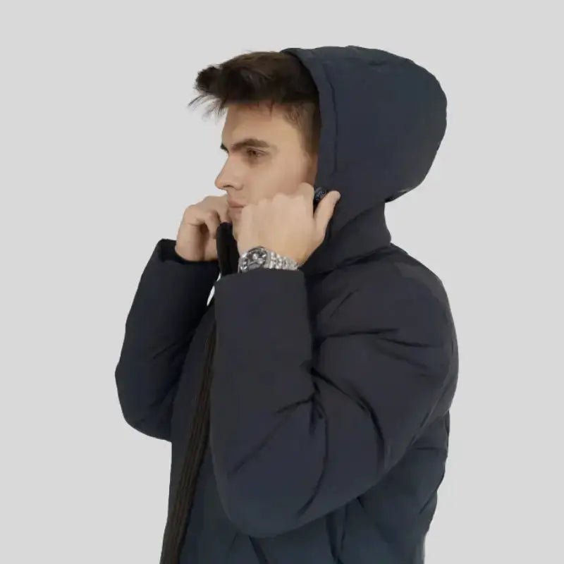 Homme portant une parka homme grande taille à capuche de couleur noire, ajustant la capuche.