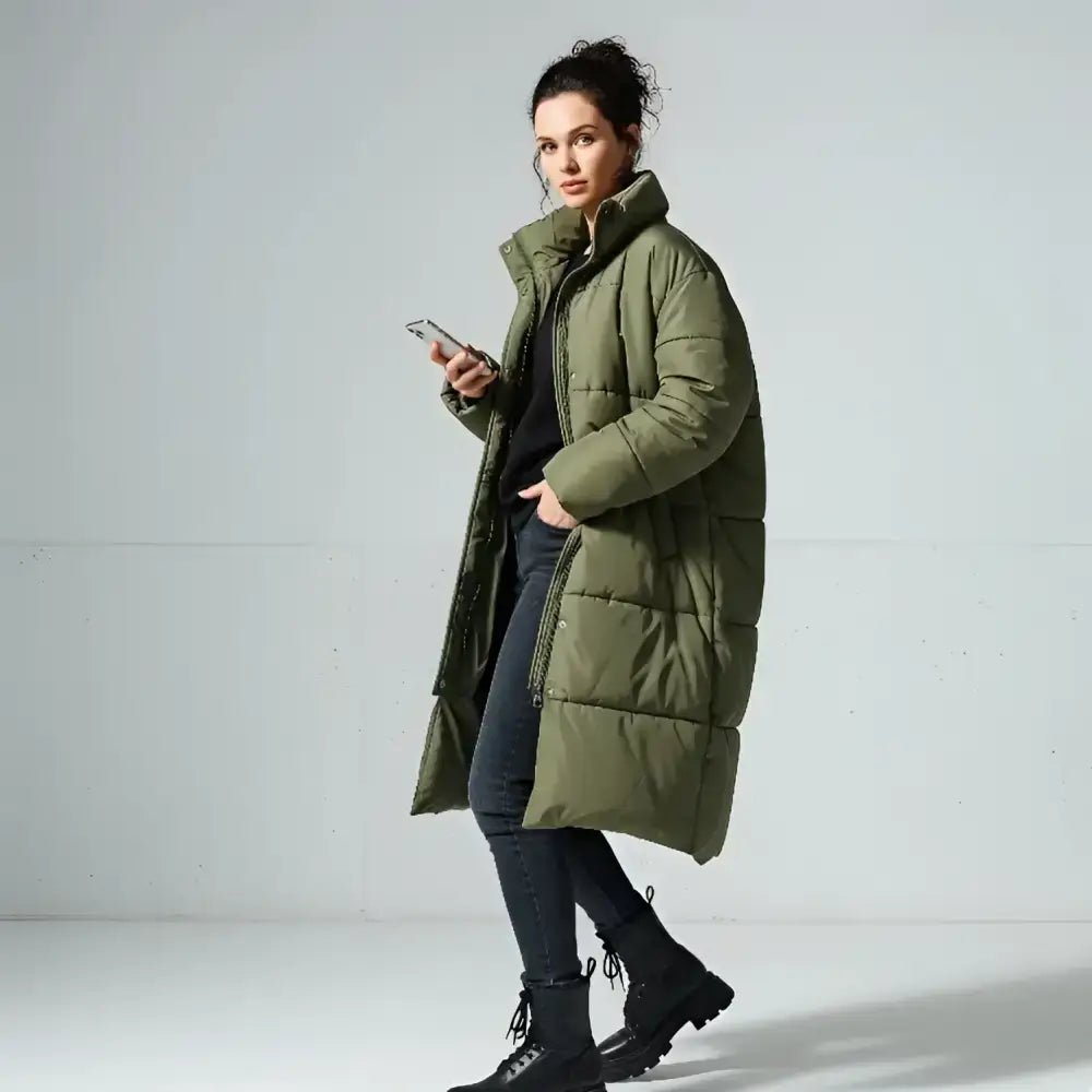 Parka femme longue matelassée colorée à capuche en vert militaire portée par une femme.
